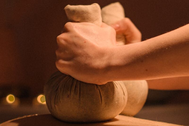 Close-up of a soothing herbal compress massage for relaxation and rejuvenation.