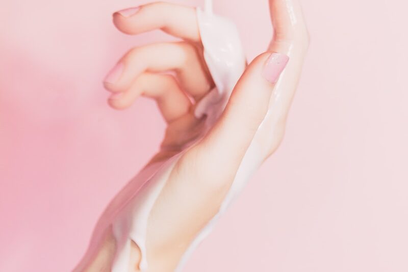 a woman's hand holding a bottle of lotion
