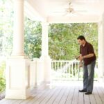 man in black t-shirt and blue denim jeans playing guitar pest control